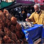 A vendor selling coconut on his cart to attract costumers.