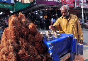 A vendor selling coconut on his cart to attract costumers.