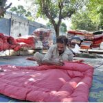 A worker busy in stitching quilt for customers at his workplace in Federal Capital.