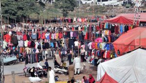 Women busy in selecting and purchasing second hand warm clothes from vendor at Shakriyal