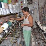 A power loom worker busy in routine work to earn livelihood at his workplace.