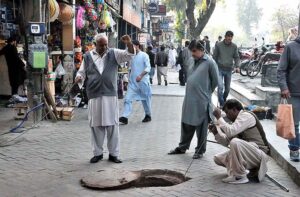 Sanitary workers busy in cleaning manhole at Aabpara in Federal Capital.