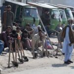 Labourers along with their tools sitting on the roadside waiting for clients to be hired for work at Khanna Pul