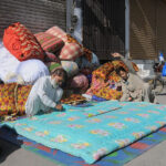 Workers stitching cotton quilts at his workplace as the demand increased for quilts after dropping mercury in the city