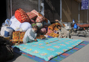 Workers stitching cotton quilts at his workplace as the demand increased for quilts after dropping mercury in the city
