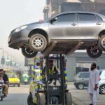 A traffic police warden removing wrongly parked vehicle with the help of fork lifter for smooth flow of traffic at Cantt area.