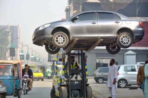  A traffic police warden removing wrongly parked vehicle with the help of fork lifter for smooth flow of traffic at Cantt area.