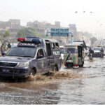 A view of vehicles passing through stagnant rain water at Jail road.