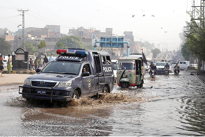 A view of vehicles passing through stagnant rain water at Jail road.