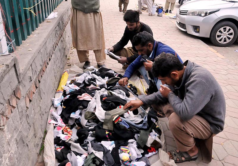 People busy in selecting and purchasing used warm clothes at weekly Sunday bazar Aabpara in the Federal Capital