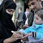 Health worker marking the finger of child after administering polio drops during anti polio campaign at Weekly Bazaar in Federal Capital.