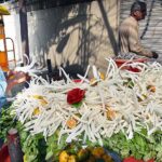 The vendor is cutting and displaying radishes to attract customers at his road side setup