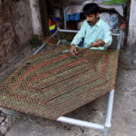 Worker busy in knitting traditional bed (charpai) at their workplace in the Provincial Capital.
