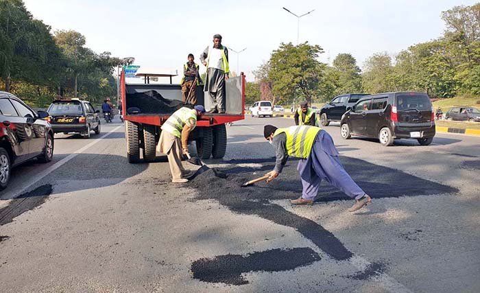 CDA staffers busy in patches work on Express way near Zero Point during maintenance work in the Federal Capital.
