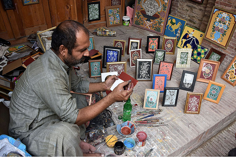 A man busy in painting stuff at outside the Masjid Wazir Khan