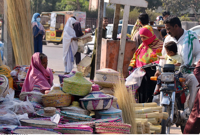Elder woman vendor displaying and selling handmade and other household items to earn a livelihood Elder woman vendor displaying and selling handmade and other household items to earn a livelihood