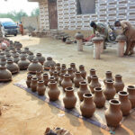 Workers are busy preparing clay-made pots at their workplace.