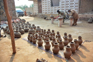 Workers are busy preparing clay-made pots at their workplace. 