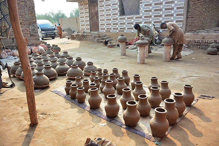 Workers are busy preparing clay-made pots at their workplace.