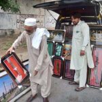 Vendor displaying and selling decoration frames to attract the customers during his roadside setup at Northern bypass