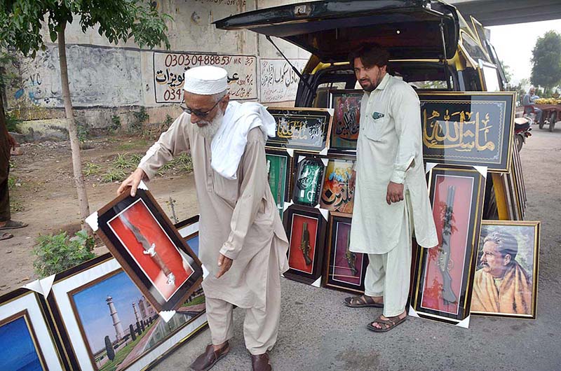 Vendor displaying and selling decoration frames to attract the customers during his roadside setup at Northern bypass