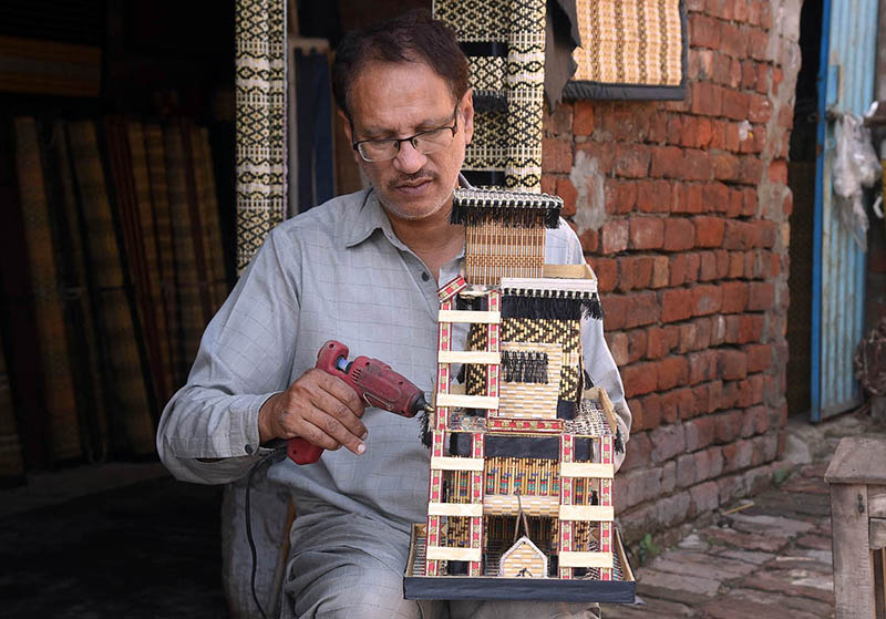 Worker busy in giving final touch on the decoration piece at his work place