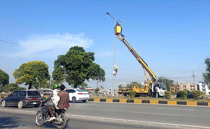CDA workers busy in maintenance of street lights at Expressway in the Federal Capital.