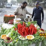A vendor displaying carrots and radish to attract the customers.