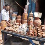 A vendor displacing clay-made items to attract the customers at Goods Naka Road