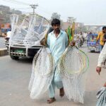 A vendor displaying birds catching nets to attract customers at Birds Market