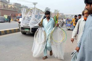 A vendor displaying birds catching nets to attract customers at Birds Market