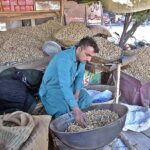 A vendor displaying peanuts to attract the customers at Rawat