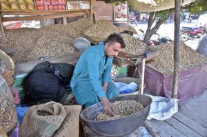 A vendor displaying peanuts to attract the customers at Rawat