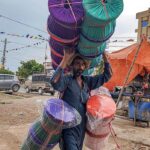 A street vendor in Khanna carrying straw-made stools and looking for customers.