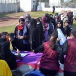 A large number of girls students standing in a queue to register for open trials for the Elite Women's Cricket League under the Lodhran Pilot Project (LPP) at Groundup Academy.