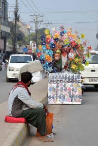 A vendor displaying colorful fish to attract customers at his roadside setup