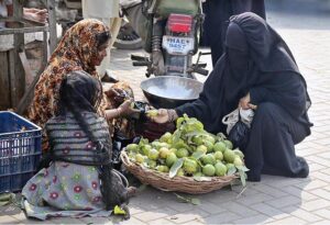  A woman purchasing guavas from roadside woman vendor