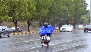 A motorcyclists on the way while cover with raincoat to protect from rain at Islamabad Expressway during light showers that experienced the Federal Capital. 