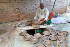 An elderly artisan busy in preparing traditional clay pots at Noorwala