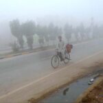 A cyclist on the way during thick fog at Sargodha Road during morning
