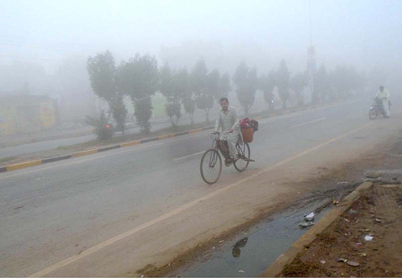 A cyclist on the way during thick fog at Sargodha Road during morning