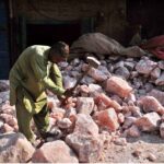 A worker busy in breaking pink salt into pieces at his workplace.
