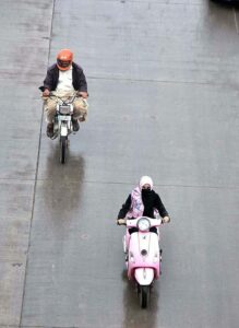 A motorcyclists on the way while cover with raincoat to protect from rain at Islamabad Expressway during light showers that experienced the Federal Capital.