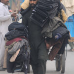 A street vendor displaying and selling jackets while shuttling on Hussain Agahi Road