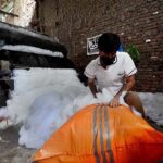 Laborer busy in filling polyester in a sack before selling in the market at Gabgari area.