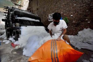  Laborer busy in filling polyester in a sack before selling in the market at Gabgari area.