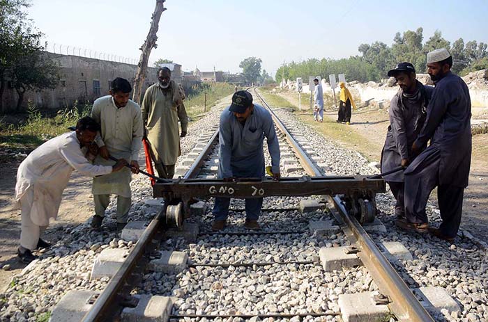 Railway staffers pushing railway track push cart on a track for repairing the track near Haji capm.