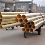 Tricycle Rickshaw holder is on the way loaded with plastic pipes at Waterworks road.