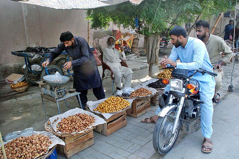 Vendor displaying and selling different verities of dates to attract customers at roadside