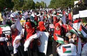 Students showing solidarity with the children of Palestine during march at Charing Cross Chowk, Main Peshawar Road.